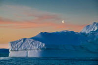 Rising moon over iceberg